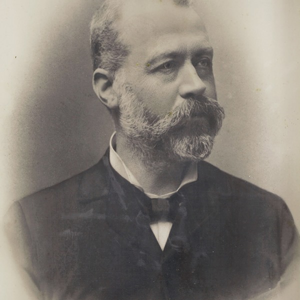 Carlo Forlanini guarda in lontananza in questa fotografia d'epoca, con piglio deciso ma sguardo bonario. Il volto è di tre quarti e risaltano i baffoni in guisa di fedine e la barba corta sul mento.